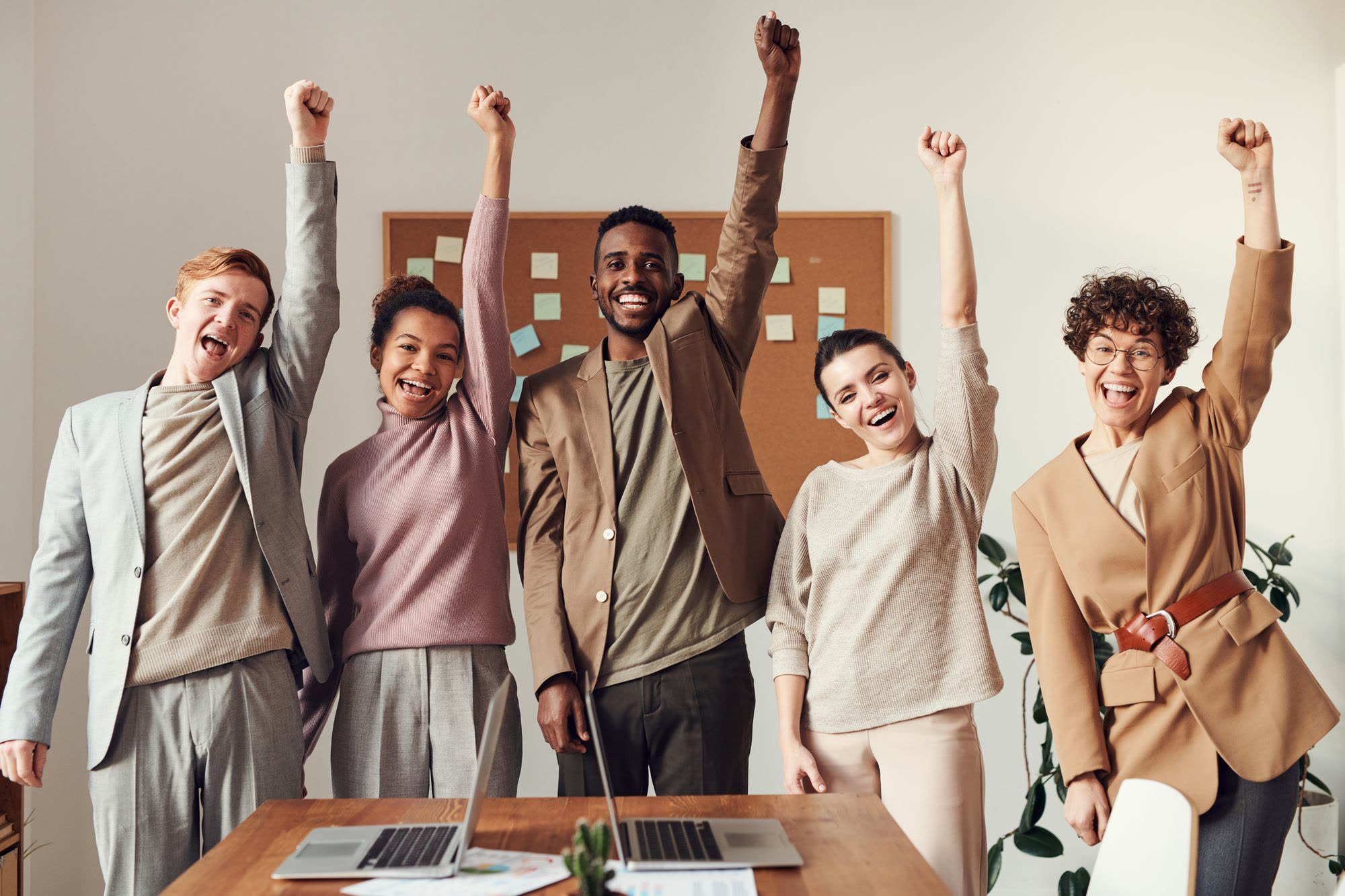 A team celebrating with raised hands in an office